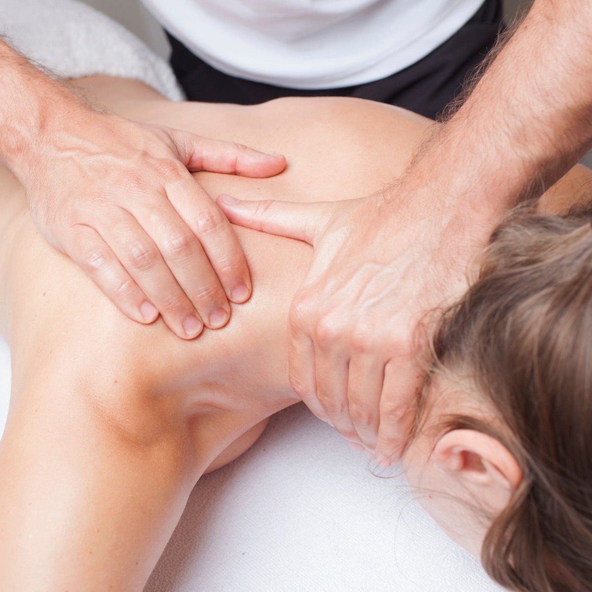 Nackenmassage: Therapeutenhände massieren gezielt Schulter-Nacken-Bereich für Schmerzlinderung während einer Wellness-Massage im ZAR Kiel.